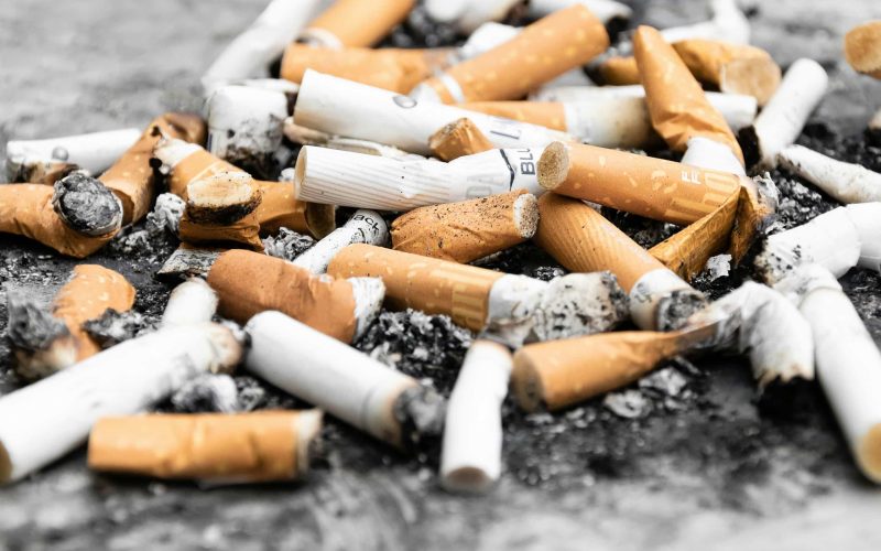 orange cigarette butts on black surface